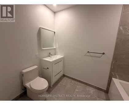 A bathroom with a toilet, sink, and mirror.