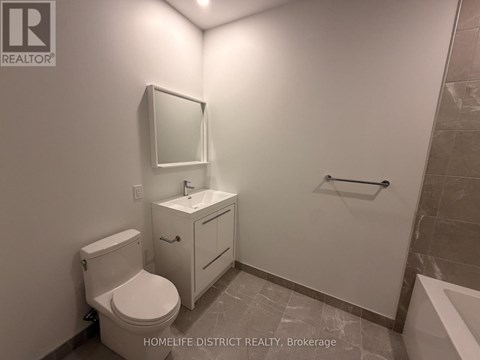 A bathroom with a toilet, sink, and mirror.