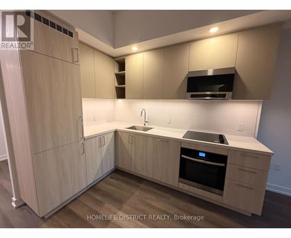 A kitchen with wooden cabinets and a stainless steel oven.