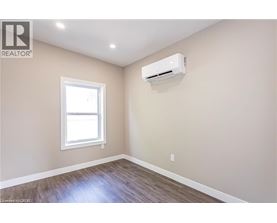 A room with a window and an air conditioner unit mounted on the wall.