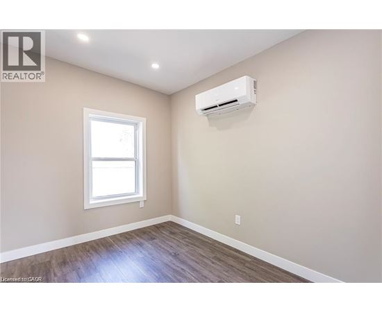 A room with a window and an air conditioner unit mounted on the wall.