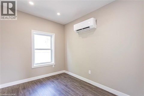 A room with a window and an air conditioner unit mounted on the wall.