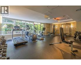 A gym with a variety of equipment including treadmills, weights, and exercise machines.