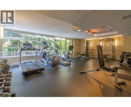 A gym with a variety of equipment including treadmills, weights, and exercise machines.