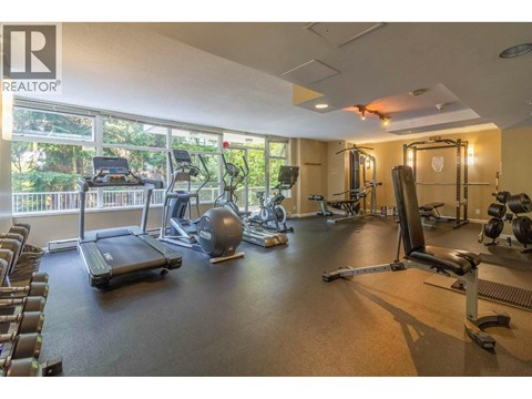 A gym with a variety of equipment including treadmills, weights, and exercise machines.