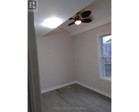 A room with a ceiling fan and a window.