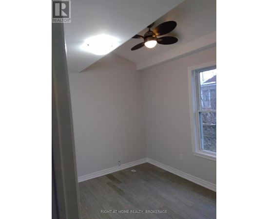 A room with a ceiling fan and a window.