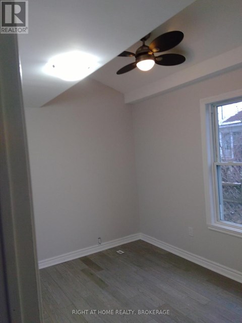 A room with a ceiling fan and a window.