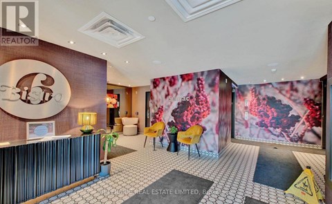 A real estate office with a reception desk and a large mural on the wall.