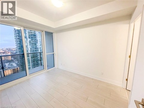 A spacious room with a view of the city through large windows.