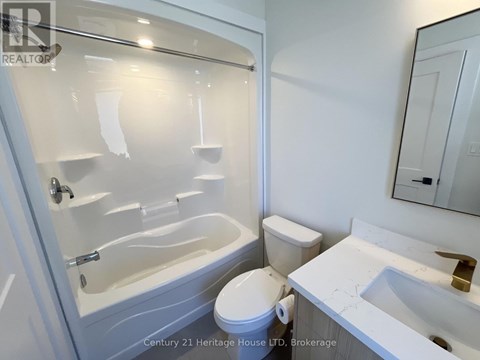 A white toilet sits next to a bathtub in a bathroom.