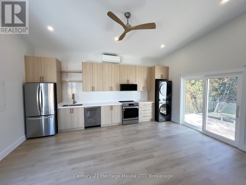 A spacious kitchen with wooden cabinets and a stainless steel refrigerator.