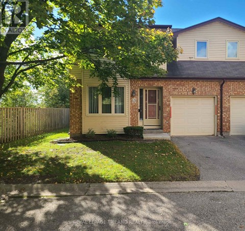 A house with a garage and a tree in front.