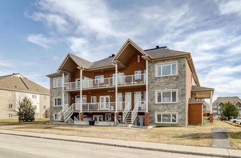 A large, multi-story residential building with a balcony on the second floor.