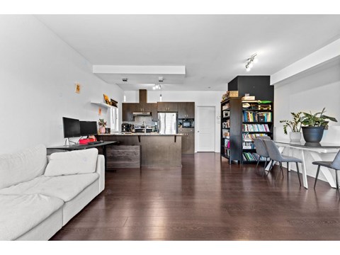 A living room with a white couch and a wooden floor.
