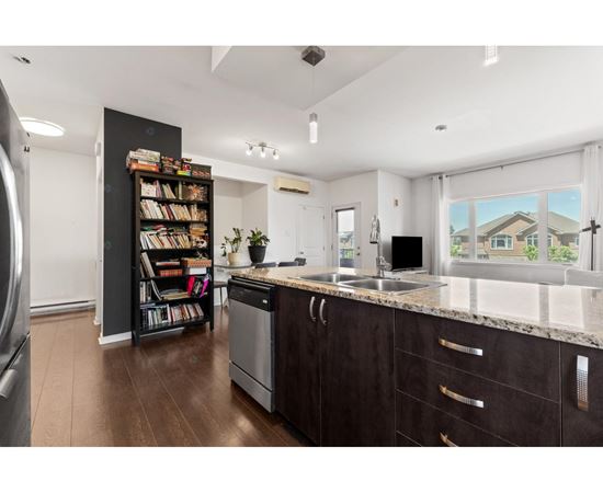 A kitchen with dark wood cabinets and a large window.