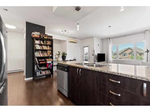 A kitchen with dark wood cabinets and a large window.