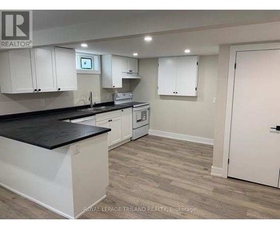 A kitchen with white cabinets and a black countertop.