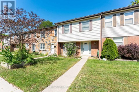 A residential building with a well-maintained lawn and a clear sky.
