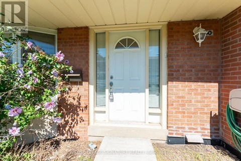A white door is on the front of a brick house.