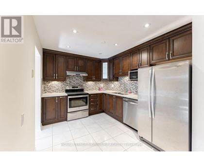 A kitchen with brown cabinets and a stainless steel refrigerator.
