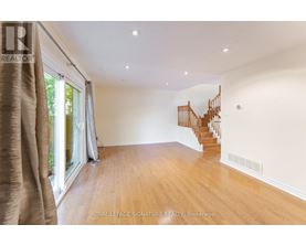 A spacious room with wooden floors and a curved staircase.