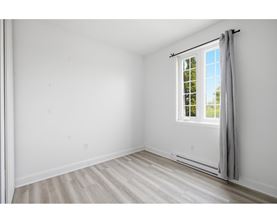 A room with a window and a grey curtain.