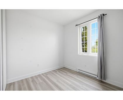 A room with a window and a grey curtain.