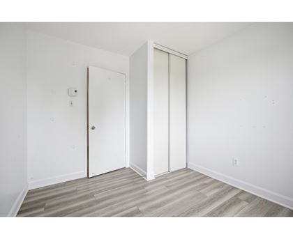 A room with a white door and a white wall.