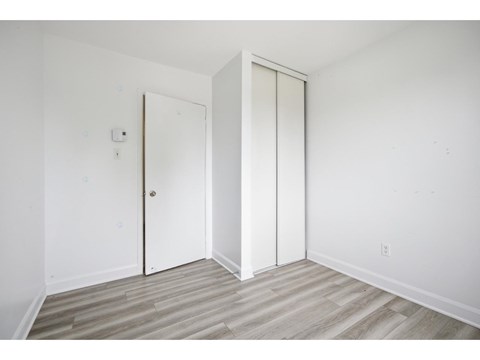 A room with a white door and a white wall.