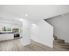 A white interior space with a staircase leading to a second floor.