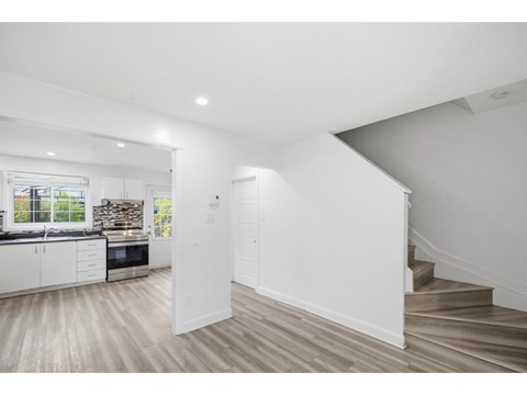 A white interior space with a staircase leading to a second floor.