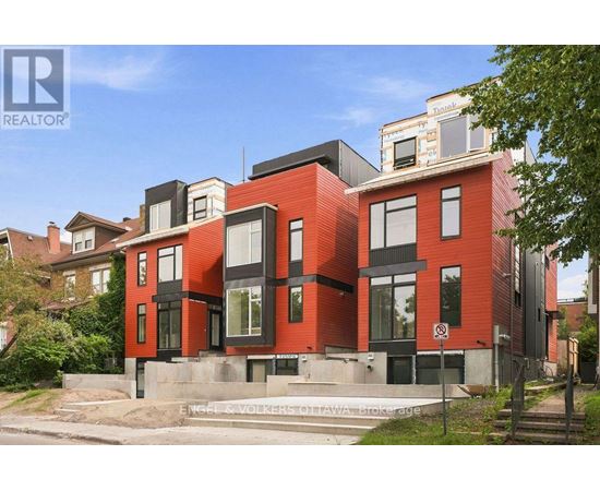 A modern red brick house with black accents and a no parking sign in front.