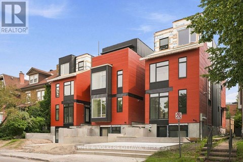 A modern red brick house with black accents and a no parking sign in front.