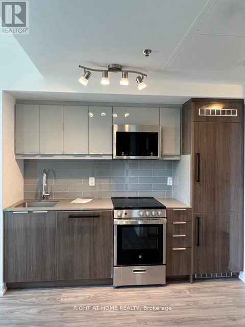 A modern kitchen with a stainless steel oven and microwave.