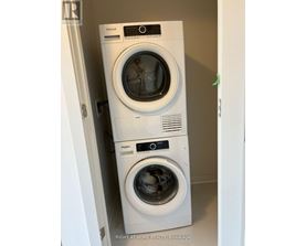 Two Whirlpool washing machines stacked on top of each other.