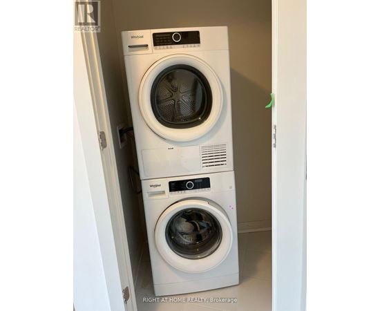 Two Whirlpool washing machines stacked on top of each other.