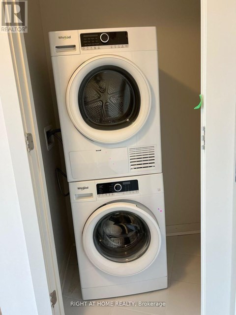 Two Whirlpool washing machines stacked on top of each other.