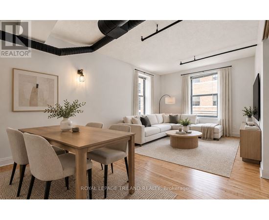 A well-lit, modern living room with a dining table and chairs.
