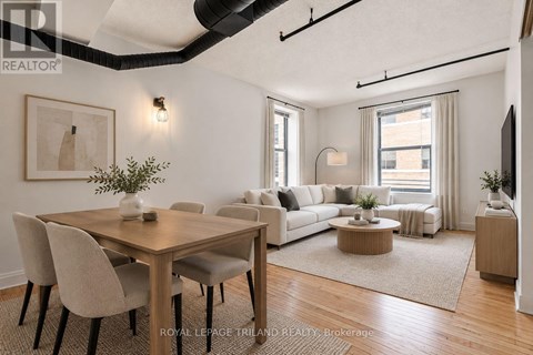A well-lit, modern living room with a dining table and chairs.