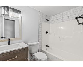 A white bathroom with a toilet, sink, and bathtub.