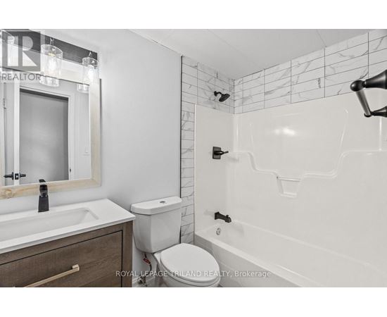 A white bathroom with a toilet, sink, and bathtub.