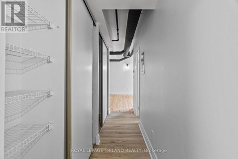 A long hallway with white walls and a wooden floor.