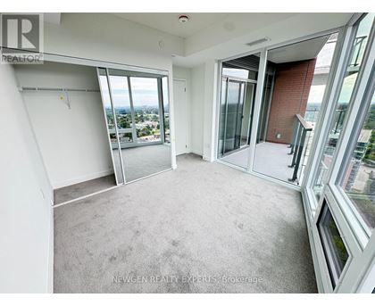 A spacious room with large windows and a view of the city.