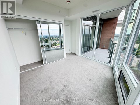 A spacious room with large windows and a view of the city.
