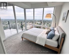 A bedroom with a large bed and a view of the city.