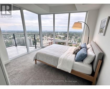 A bedroom with a large bed and a view of the city.