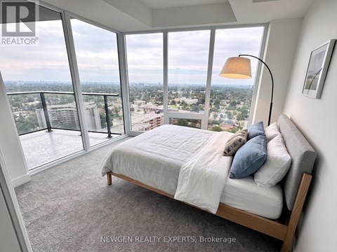 A bedroom with a large bed and a view of the city.