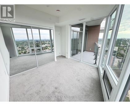 A spacious room with large windows overlooking a cityscape.