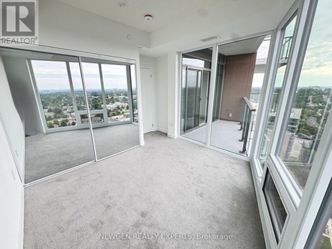 A spacious room with large windows overlooking a cityscape.